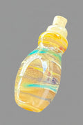 A hand-blown glass bottle with a cork stopper, featuring a warm yellow and orange body with blue and green glass swirls, isolated on a solid black background.